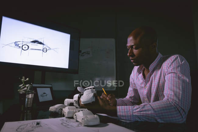 Чоловік-виконавчий вивчає модель автомобіля в офісі — стокове фото