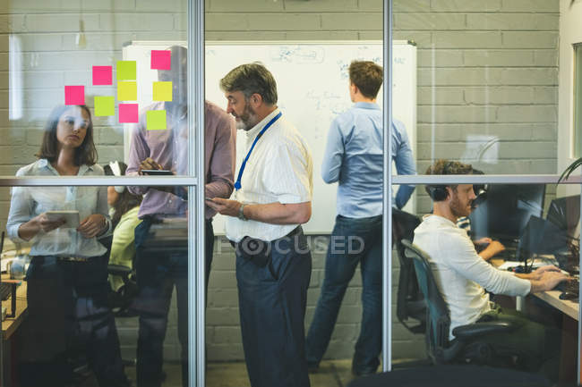 Gli uomini d'affari discutono su tablet digitale in ufficio — Foto stock