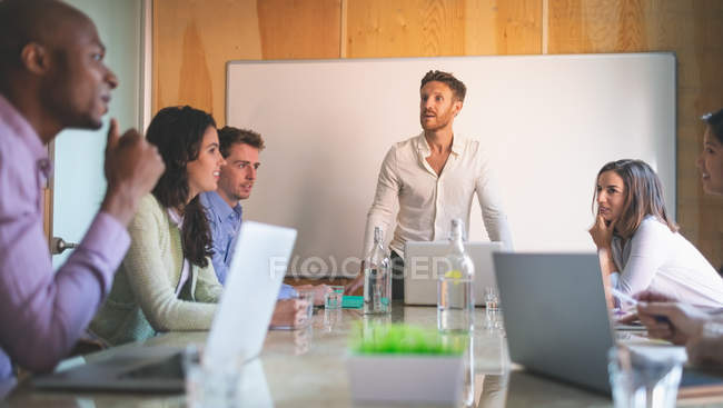 Ділові люди мають обговорення на зустрічі в офісі — стокове фото