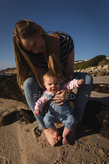 Primer plano de la madre y el bebé divirtiéndose en la playa - foto de stock
