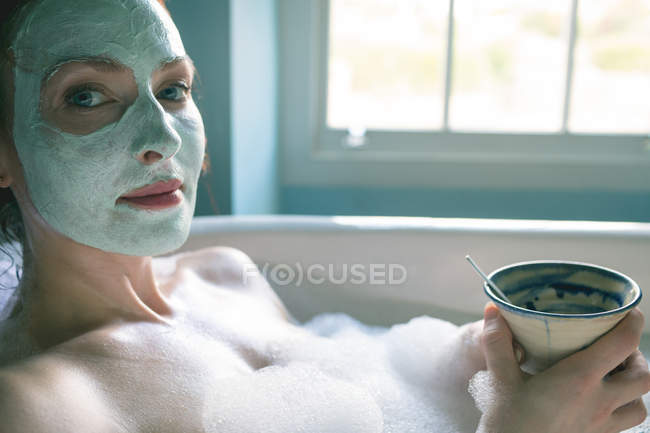 Femme avec tasse de café dans la baignoire à la salle de bain — Photo de stock