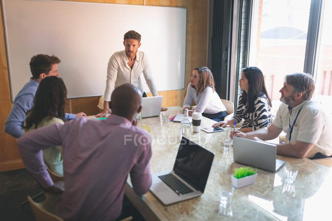 Деловые люди обсуждают на встрече в офисе — стоковое фото