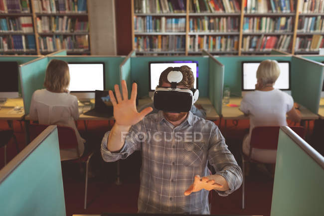 Männliche Führungskraft mit Virtual-Reality-Headset am Schreibtisch im Büro — Stockfoto