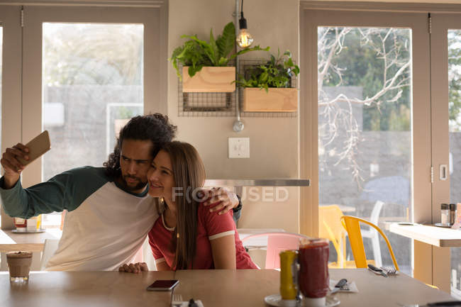 Happy couple taking selfie in cafe — Stock Photo