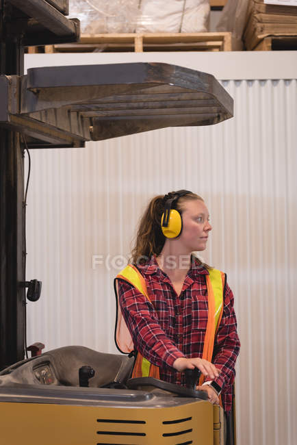 Female worker driving forklift at warehouse — Stock Photo