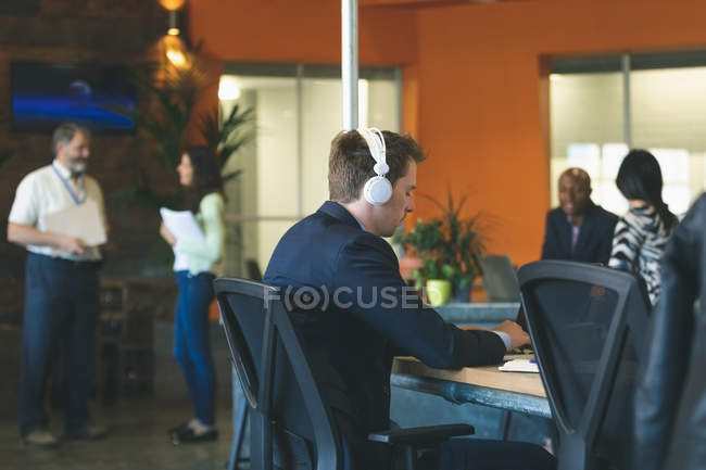 Businessman using laptop at desk in office — Stock Photo