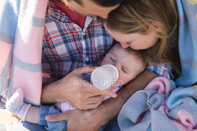 Primer plano de los padres alimentando al bebé - foto de stock