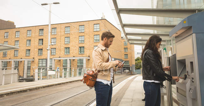 Pendler nutzen Fahrkartenautomaten am Bahnhof — Stockfoto