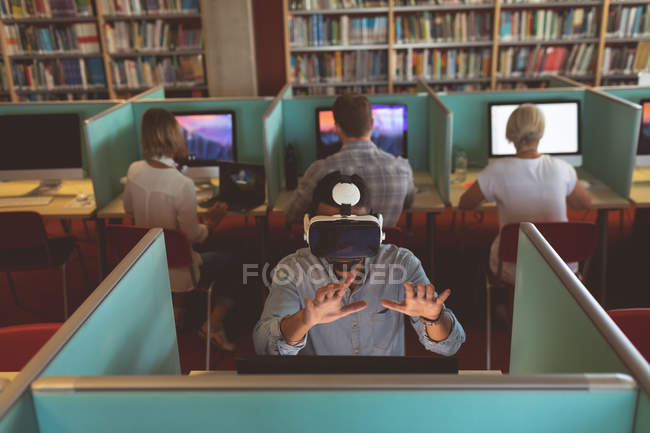 Executive using virtual reality headset at desk in office — Stock Photo