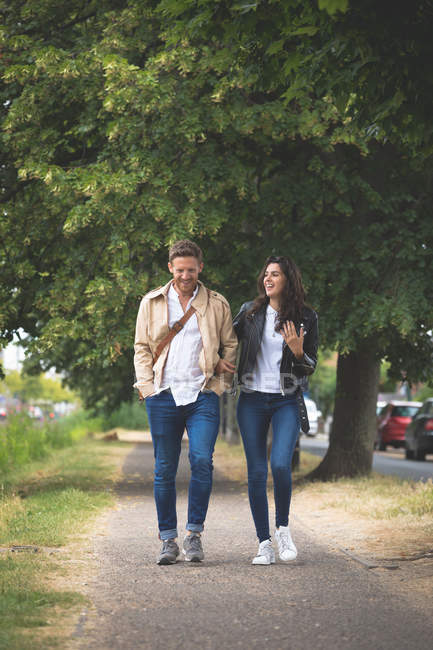Glückliches Paar interagiert beim Gassigehen auf der Straße — Stockfoto