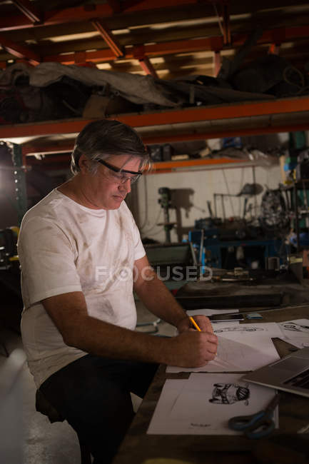 Чоловічий механік малювання модель автомобіль у гаражі — стокове фото
