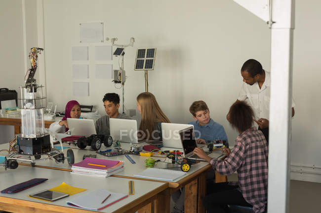 Студенты обсуждают за ноутбуком в учебном заведении — стоковое фото