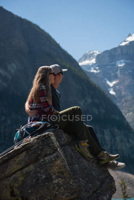 Романтична пара сидить на скелі біля гори — стокове фото