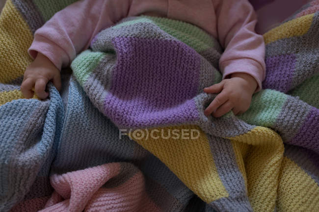 Section basse du bébé se détendre sur le lit dans la chambre — Photo de stock
