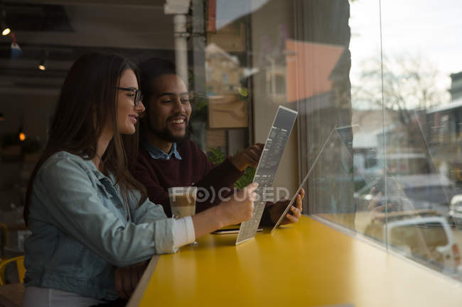 Casal jovem discutindo cartão de menu no café — Fotografia de Stock