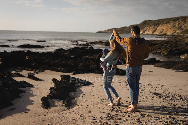 Пара танцев на пляже со своим ребенком в солнечный день — стоковое фото