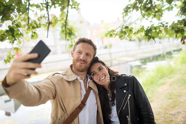 Coppia romantica scattare selfie vicino lago lato — Foto stock