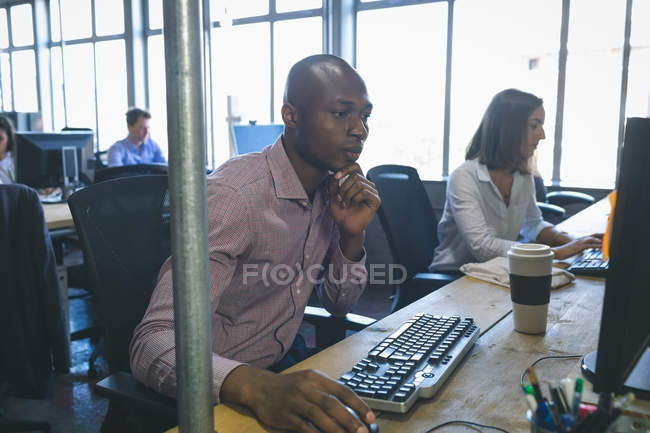 Бізнес-колеги, що працюють за комп'ютером за столом в офісі — стокове фото