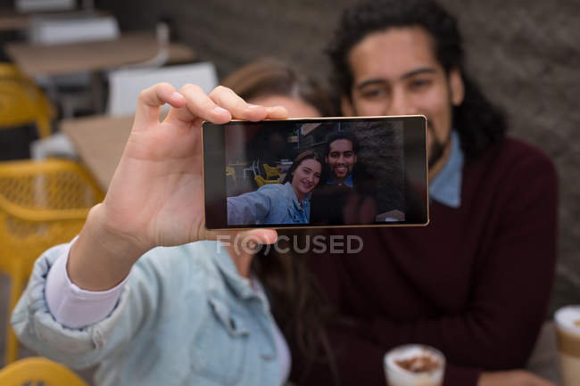 Primo piano di coppia che prende selfie al caffè all'aperto — Foto stock