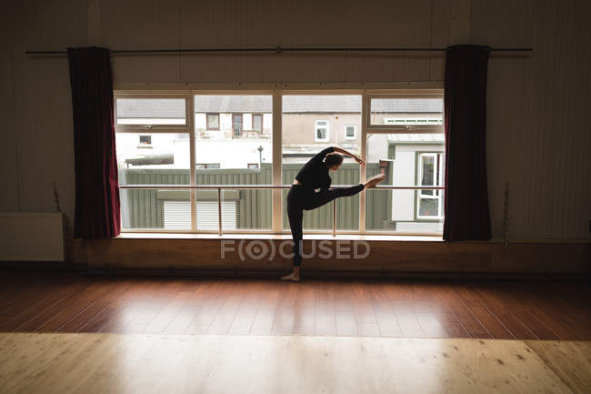 Ballerina pratica danza classica vicino alla finestra in studio di danza — Foto stock
