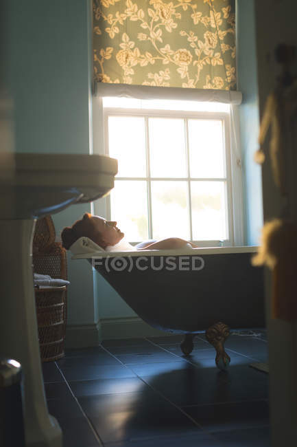 Femme prenant un bain dans la baignoire à la salle de bain — Photo de stock
