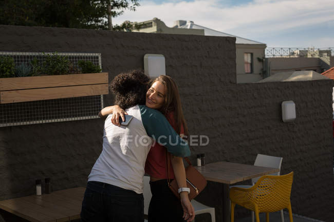 Счастливая пара обнимает друг друга в кафе на открытом воздухе — стоковое фото