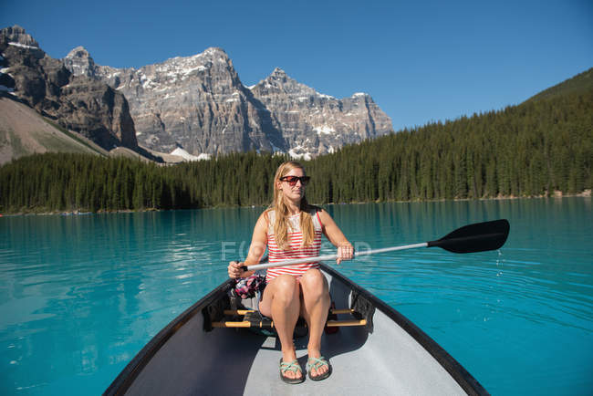 Женщина катается на лодке по реке в солнечный день — стоковое фото