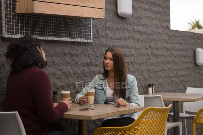 Junges Paar unterhält sich im Freiluftcafé — Stockfoto