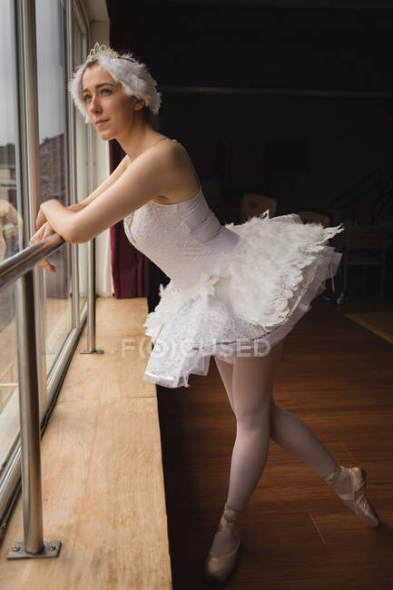 Thoughtful ballerina looking through window in dance studio Ballet Studio, ballet - Stock Photo | #212451782