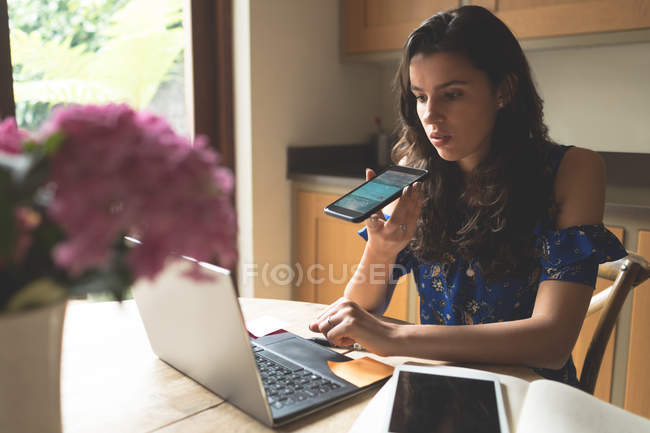 Woman talking on mobile phone at home — Stock Photo