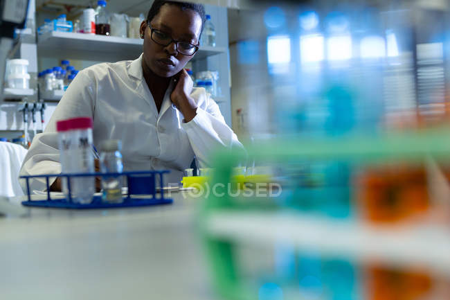 Cientista feminina atenta experimentando em laboratório — Fotografia de Stock