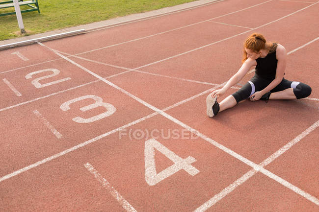Jovem atlética se exercitando na pista de corrida — Fotografia de Stock