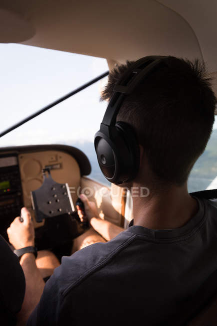 Вид сзади пилота летающего самолета в кабине пилота — стоковое фото