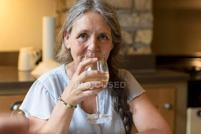 Porträt einer Seniorin, die zu Hause Wein trinkt — Stockfoto