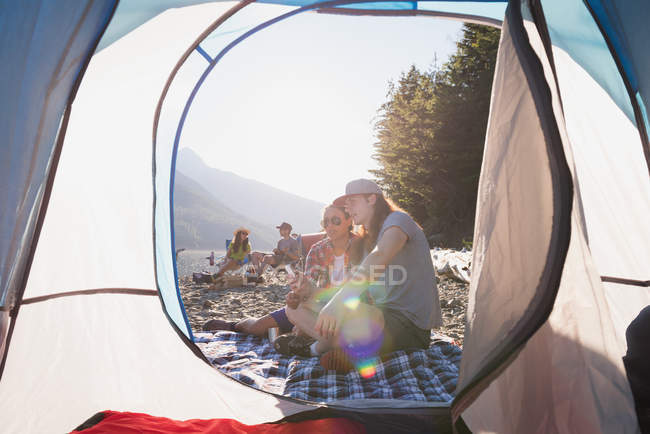 Coppia rilassante vicino tenda in una giornata di sole — Foto stock