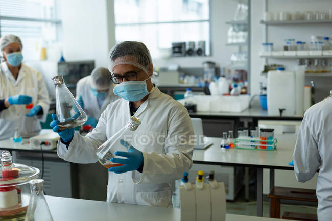 Científicos experimentando juntos en laboratorio - foto de stock