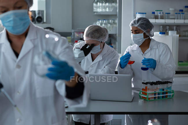 Team of scientists experimenting together in laboratory — Stock Photo