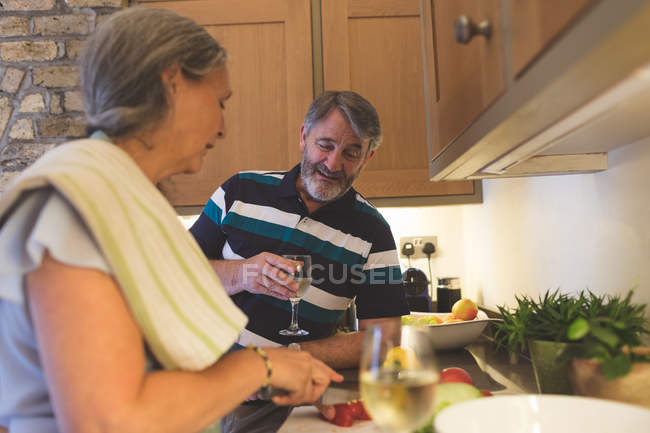 Couple sénior coupe légumes dans la cuisine à la maison — Photo de stock