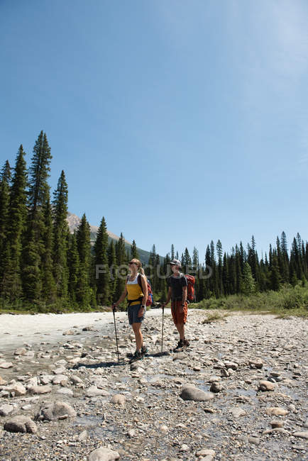 Coppia in piedi vicino al fiume in una giornata di sole — Foto stock