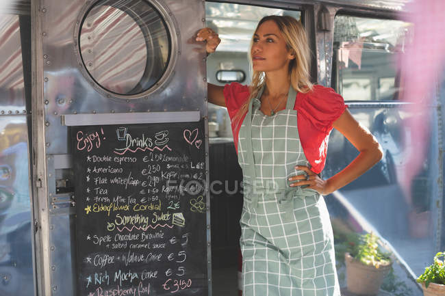 Nachdenkliche Kellnerin steht in Food-Truck — Stockfoto