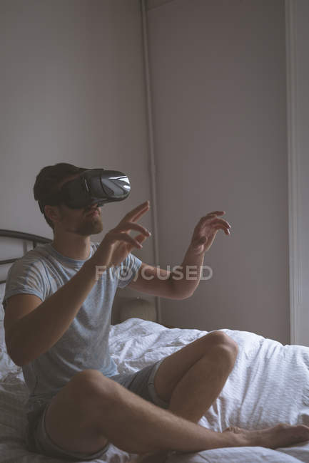 Mann benutzt Virtual-Reality-Headset im Schlafzimmer zu Hause — Stockfoto