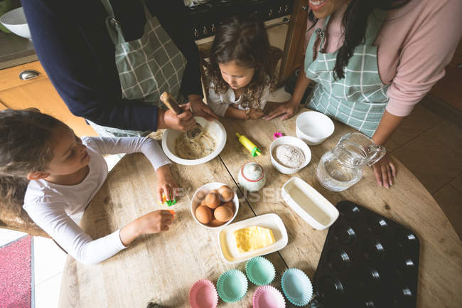 Familie bereitet Frühstück zu Hause am Esstisch zu — Stockfoto