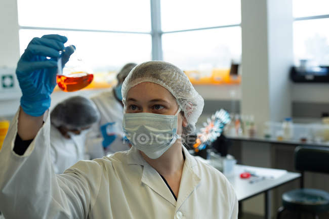 Уважний жіночий вчений експериментує в лабораторії — стокове фото