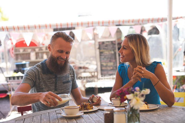 Happy couple having breakfast in outdoor cafe — Stock Photo