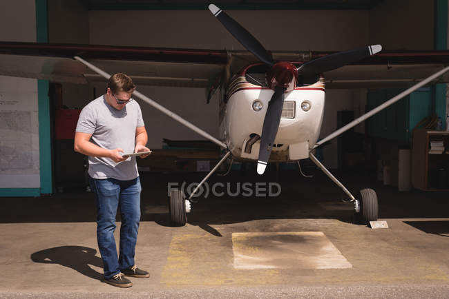 Homem usando tablet digital no hangar em um dia ensolarado — Fotografia de Stock