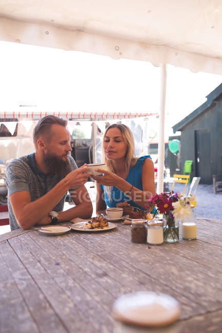 Pareja romántica tomando café en la cafetería al aire libre - foto de stock