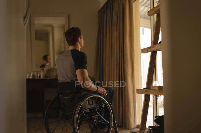 Задумчивый инвалид в инвалидной коляске дома — стоковое фото