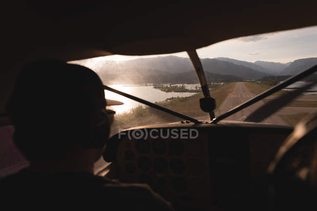 Rear view of pilot taking off aircraft on runway — Stock Photo