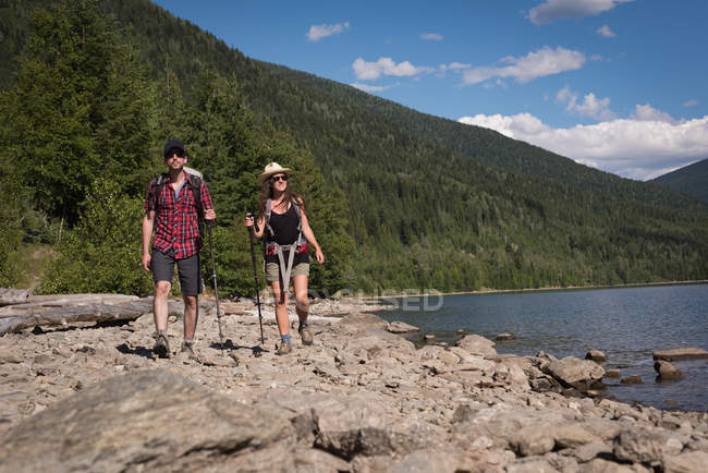 Couple marchant près de la rivière par une journée ensoleillée — Photo de stock