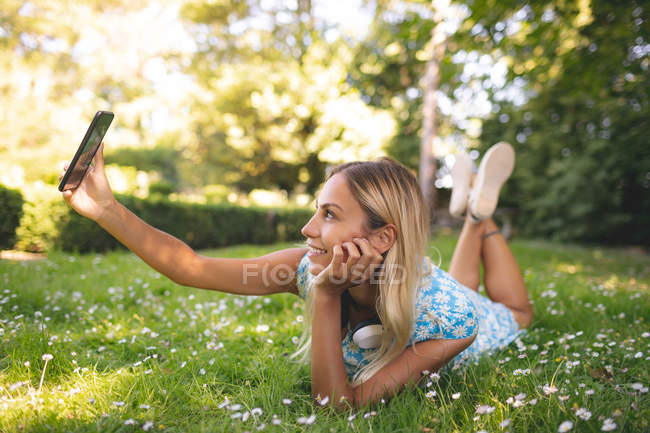 Frau macht Selfie mit Handy im Park — Stockfoto
